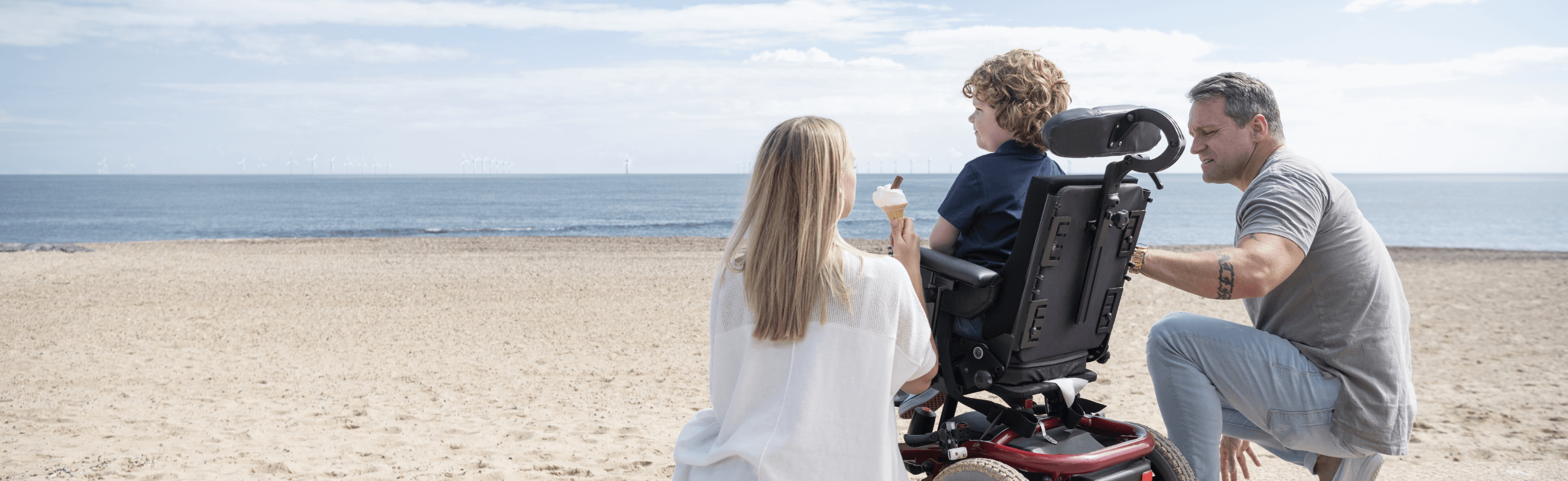 Photograph of a wheelchair-user enjoying the beach